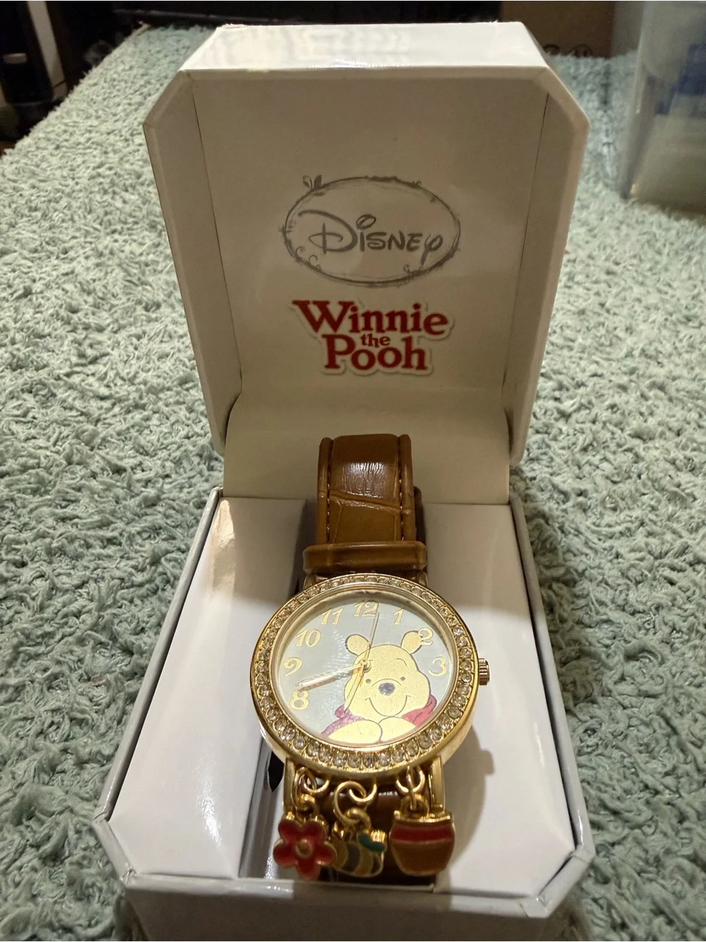 Disney Winnie the Pooh watch features a crystal-bezel dial and dangling charms o